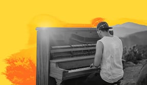 Musician sitting at a piano in the desert